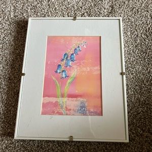White frame with a floral art print. Perfect for your powder room or hallway.
